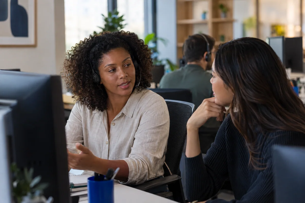 A customer-support specialist collaborating with a colleague — illustrative scene
